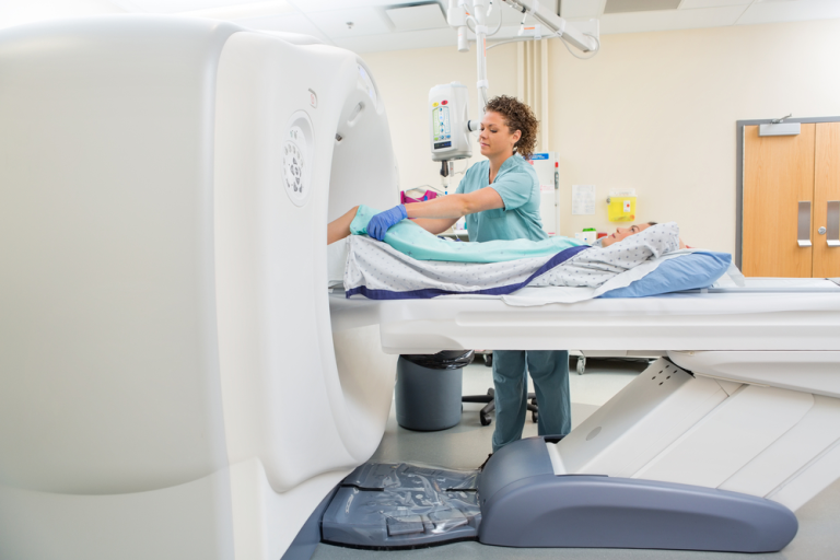 Radiographer Preparing A Patient For A Ct Scan On An Open Ring Shaped Scanner In Albury